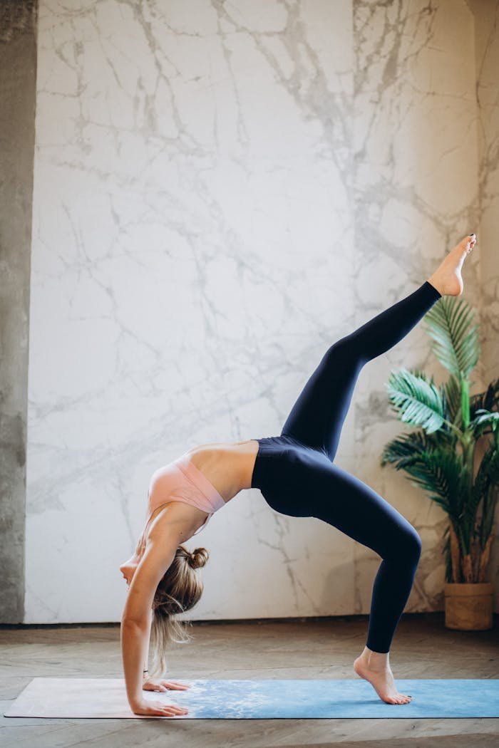 Woman practicing yoga pose indoors, emphasizing balance and flexibility.